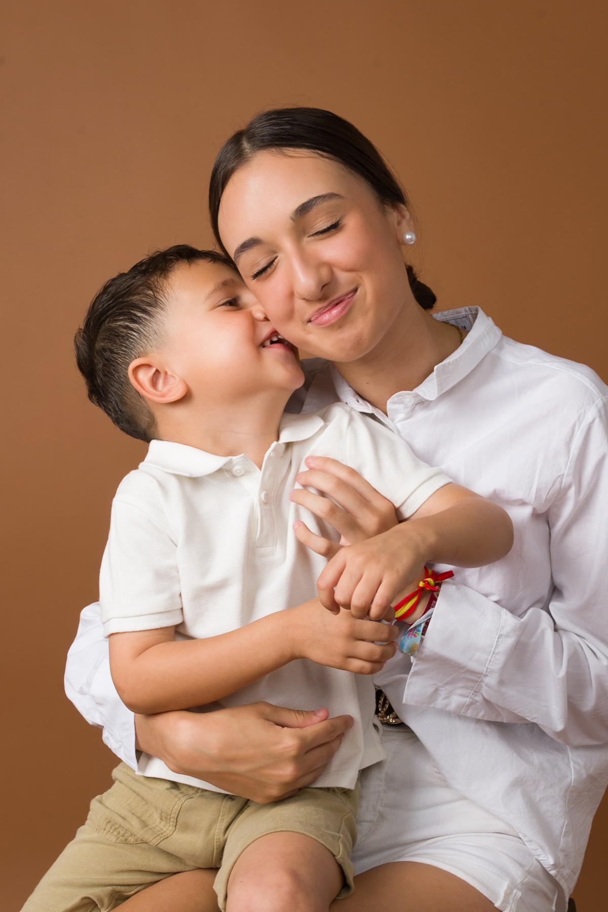 Una mujer abraza a un niño en una luz cálida.
