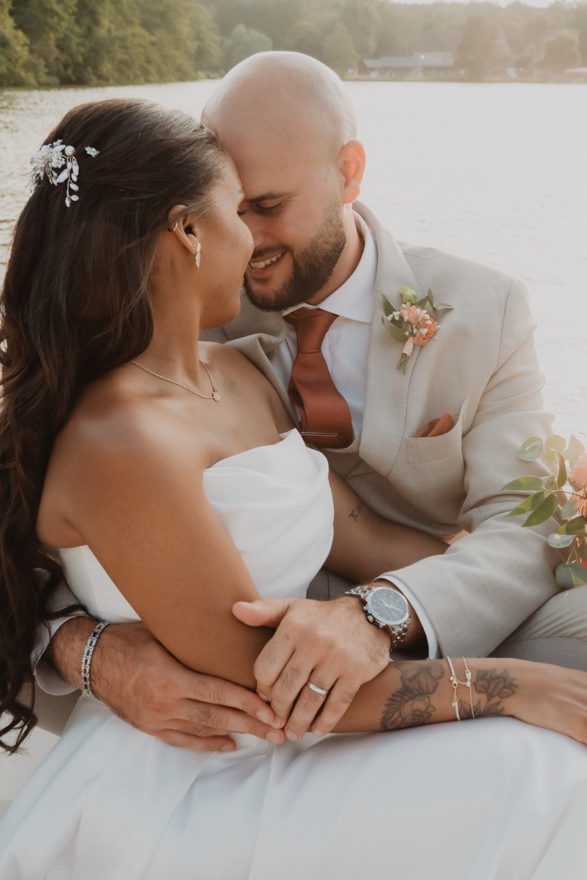 Émilie y Chris abrazados junto al agua el día de su boda.