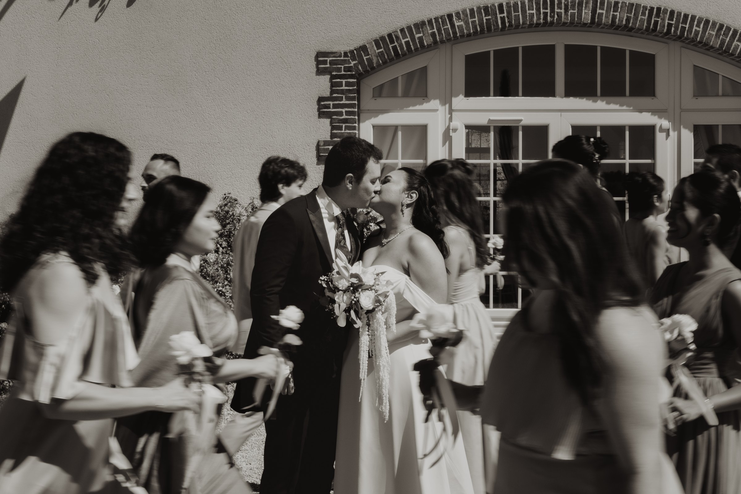 Una pareja sale de la ceremonia entre familiares y amigos en blanco y negro.