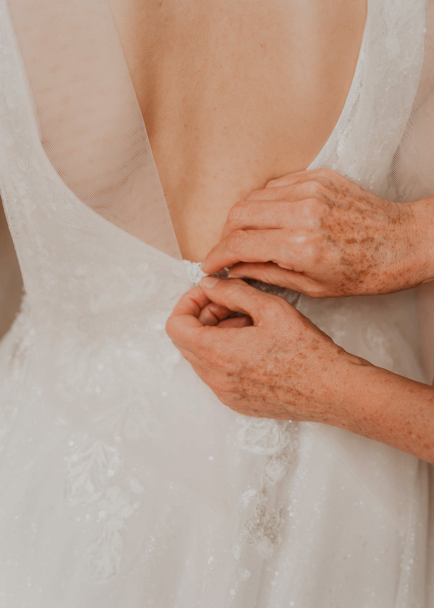 Dos familiares sujetan las manos de la novia.