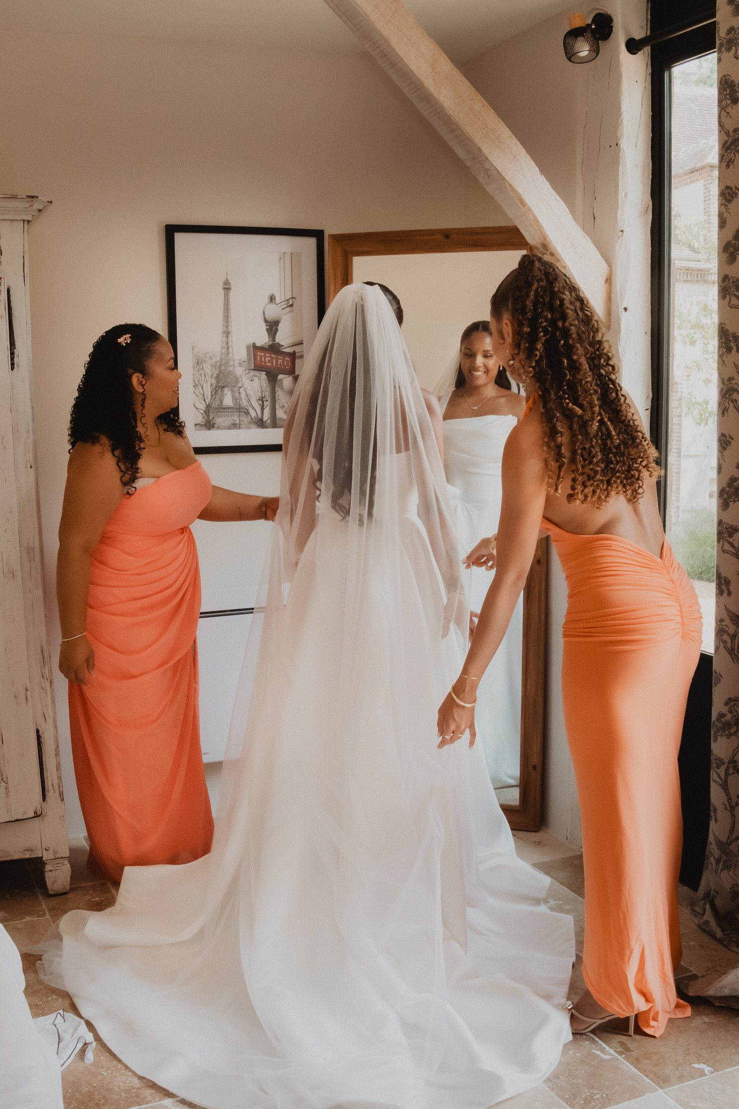 Dos amigas ayudan a colocar el velo de la novia.
