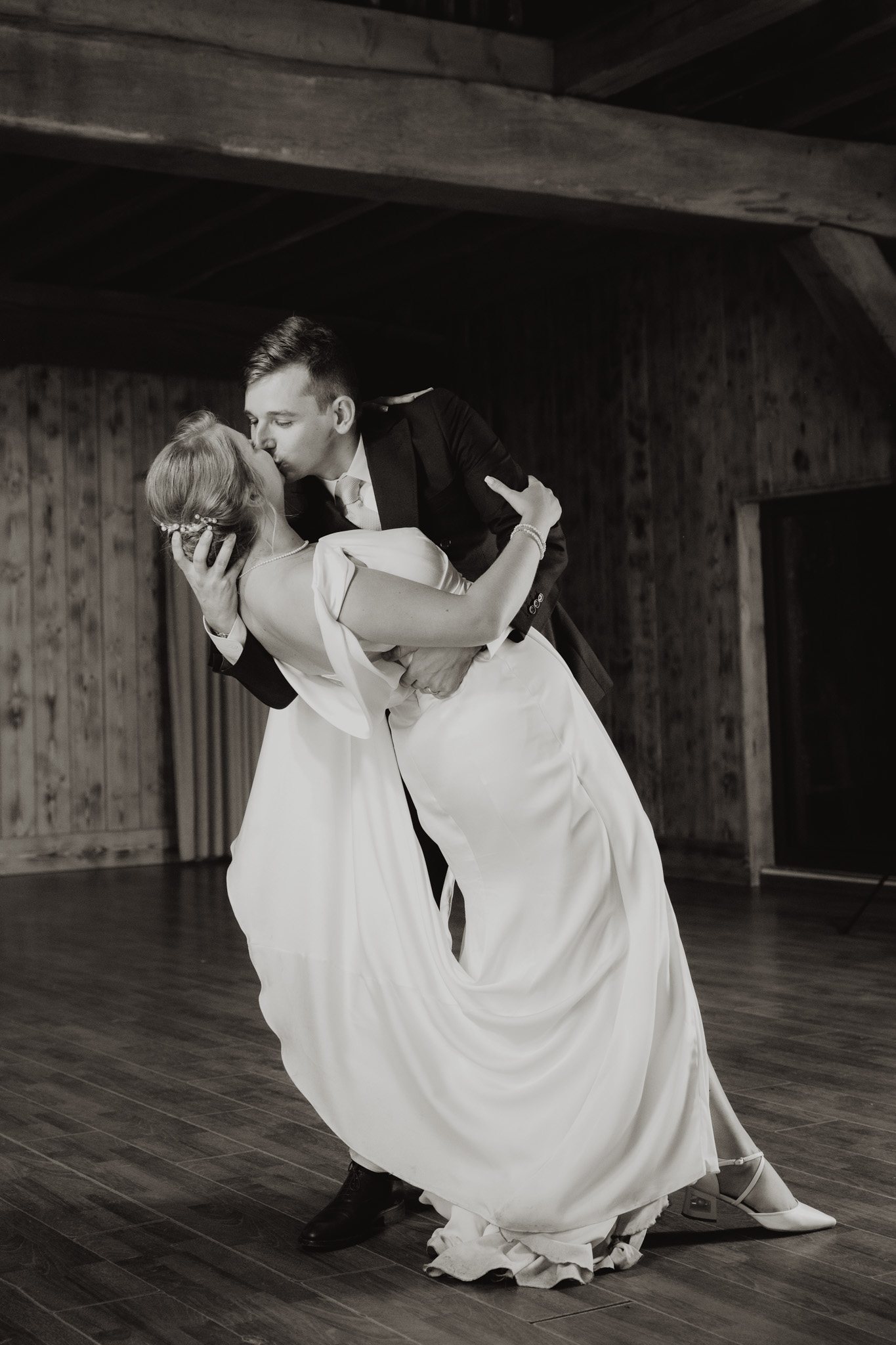 Una pareja se besa bailando en blanco y negro.