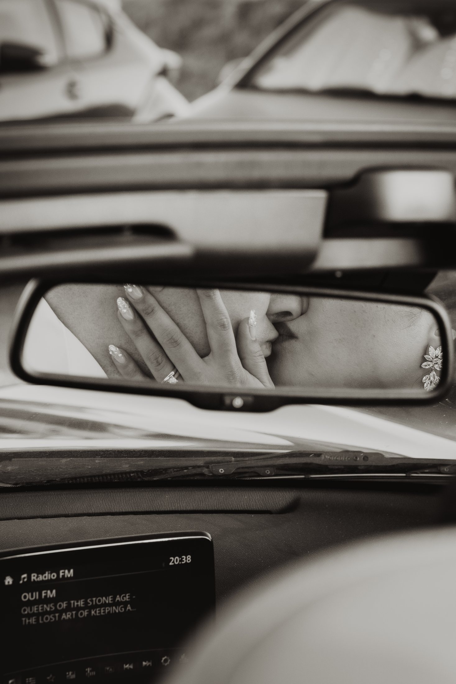 Las manos de una pareja se reflejan en el retrovisor.