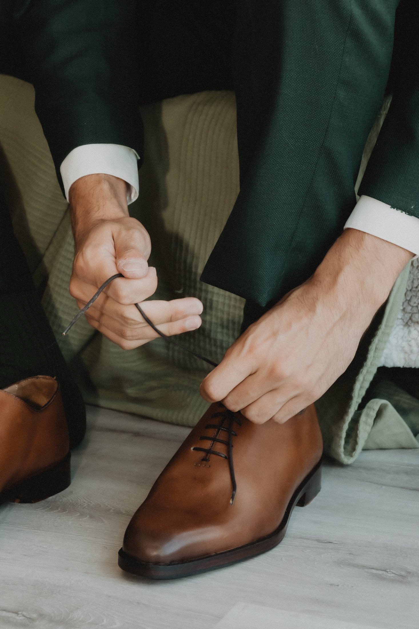 Un novio se ata los zapatos durante los preparativos.
