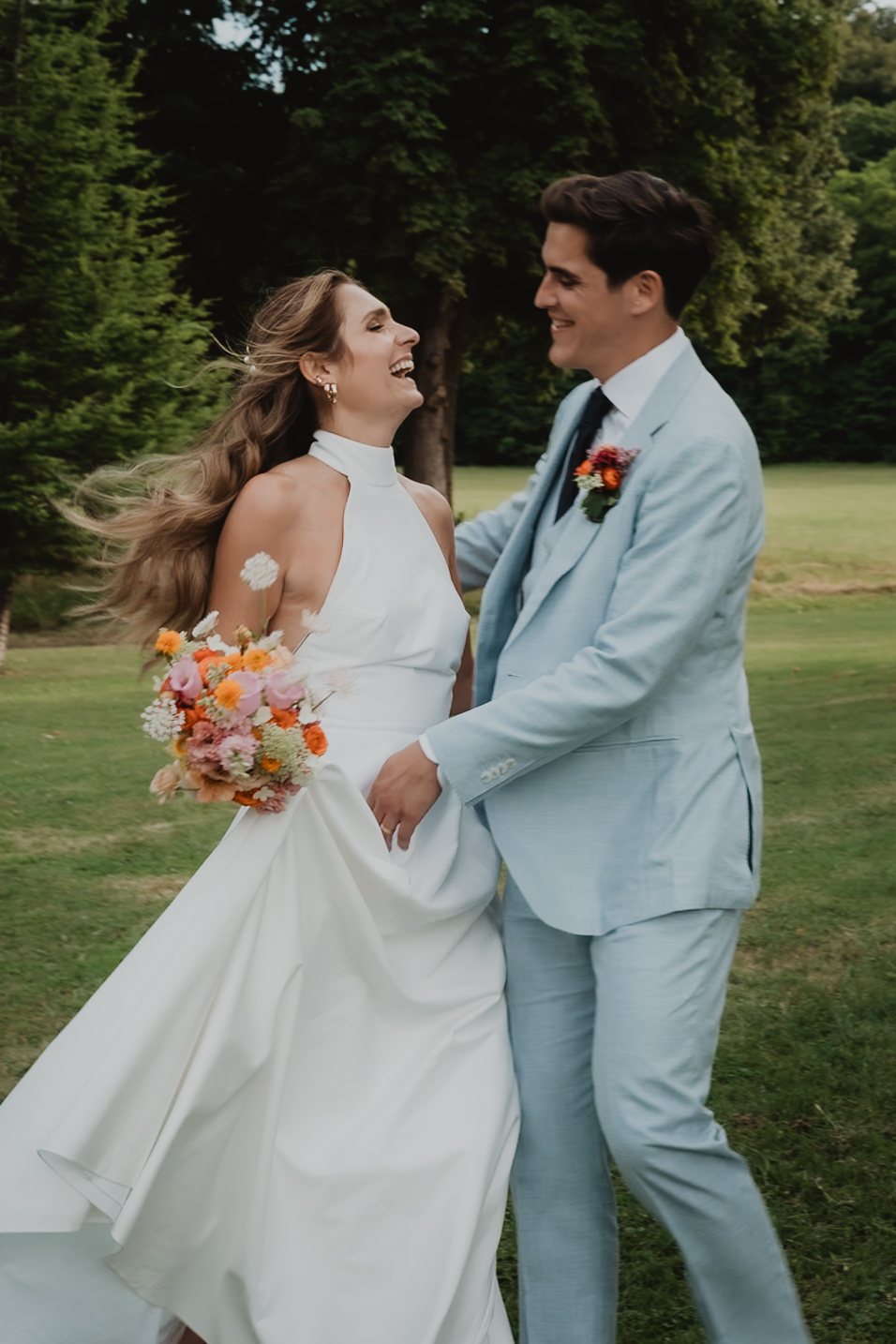 Una pareja posa abrazada con un traje azul claro.