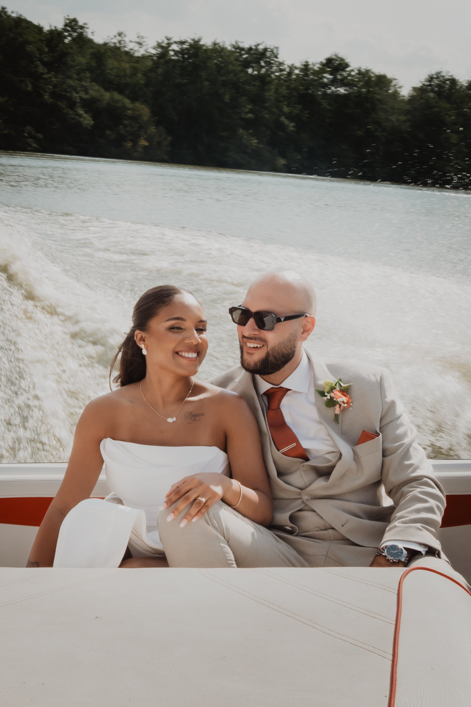 Una pareja sonríe durante una sesión de postboda en un barco.