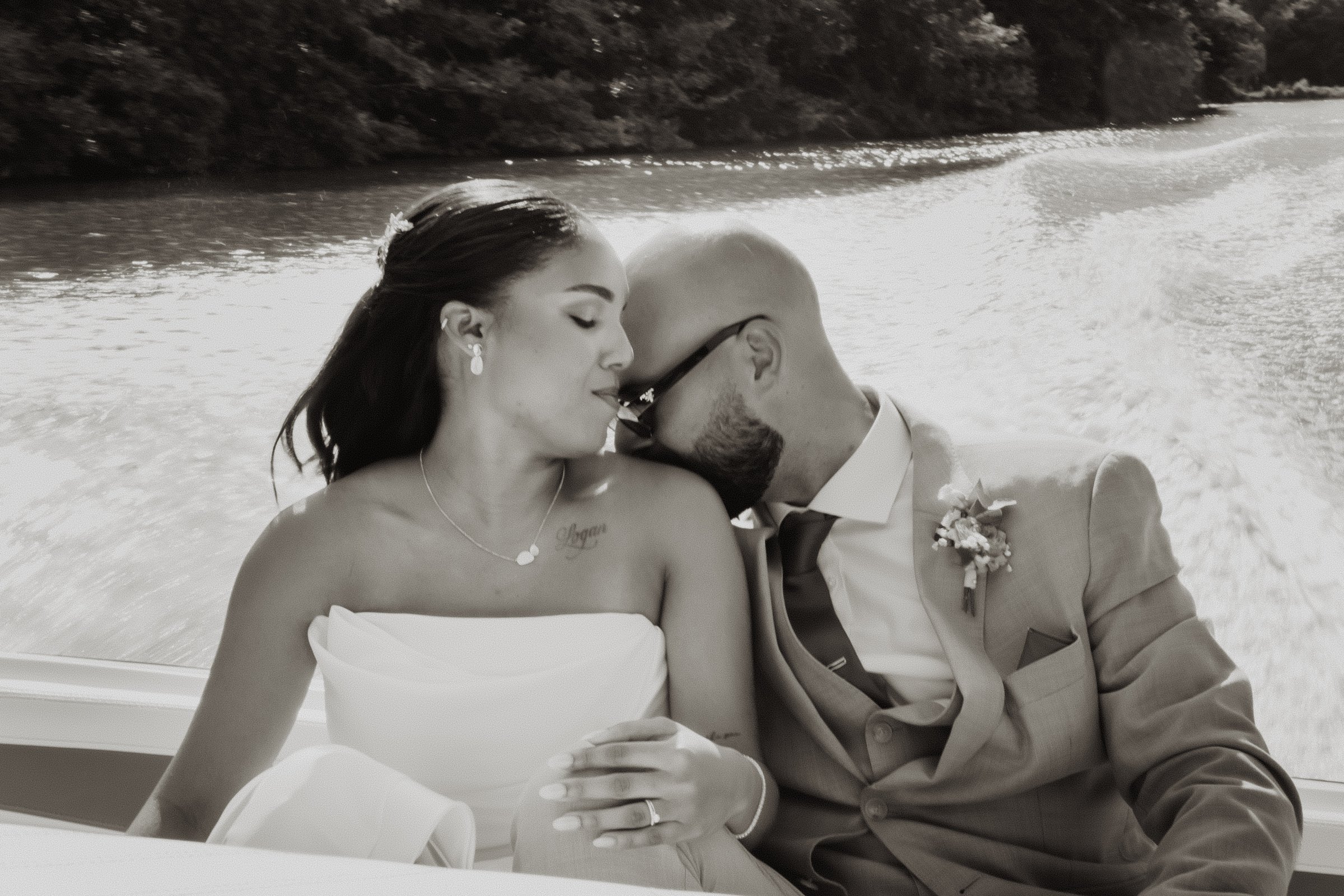 Una pareja se besa en blanco y negro durante un paseo en barco.