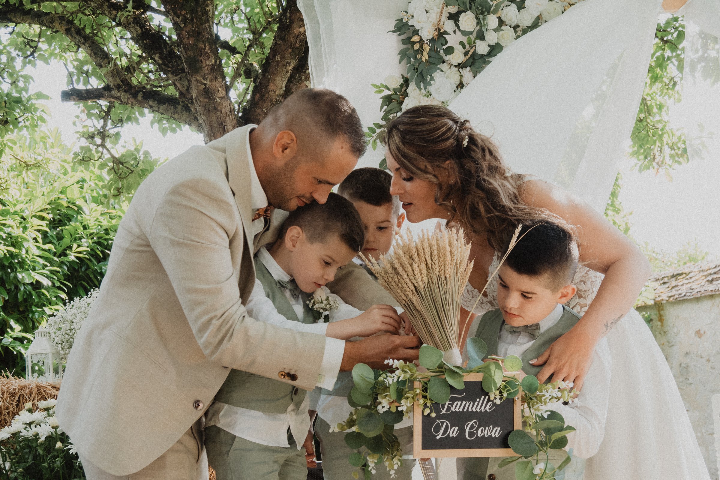 Una familia reúne sus manos durante una ceremonia al aire libre.